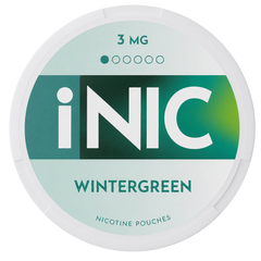 A round white plastic container of iNIC Wintergreen nicotine pouches, 3 mg strength, featuring a mint green and teal label with bold white branding.